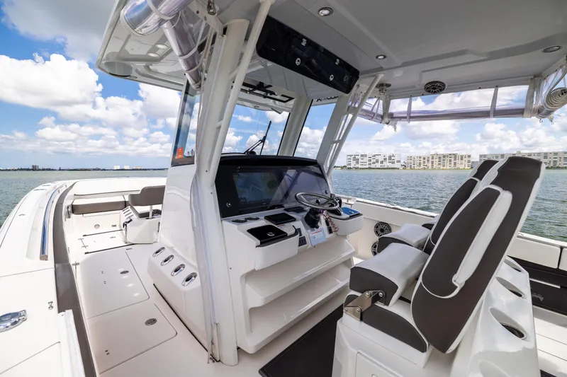 Slide: The Image of 2022 World Cat 400 CC-X boat interior with helm, seats, and ocean view. - 41