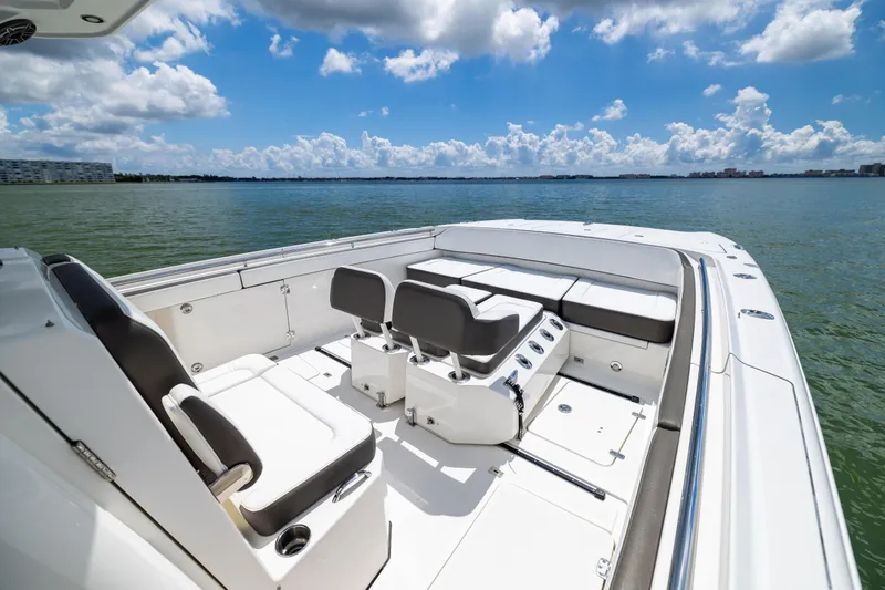 Slide: The Image of 2022 World Cat 400 CC-X boat interior with seating, on calm water under blue sky. - 53
