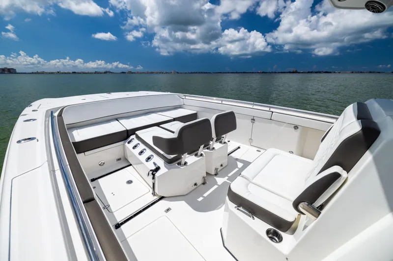 Slide: The Image of 2022 World Cat 400 CC-X boat interior with seating, on calm water under blue sky. - 54