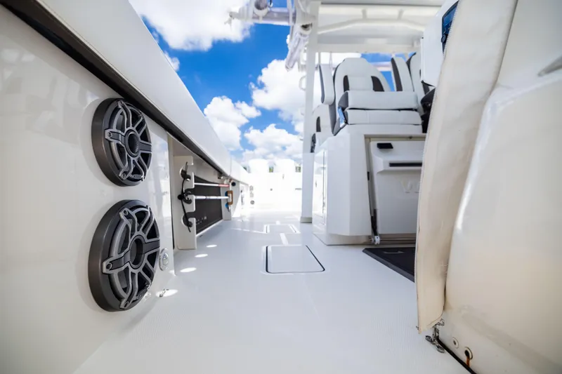 Slide: The Image of 2022 World Cat 400 CC-X boat interior with speakers and seating, under a blue sky. - 74