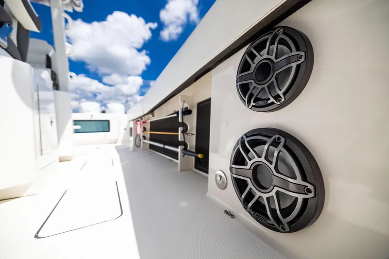 Slide: The Image of 2022 World Cat 400 CC-X boat interior with speakers, under a bright blue sky. - 76