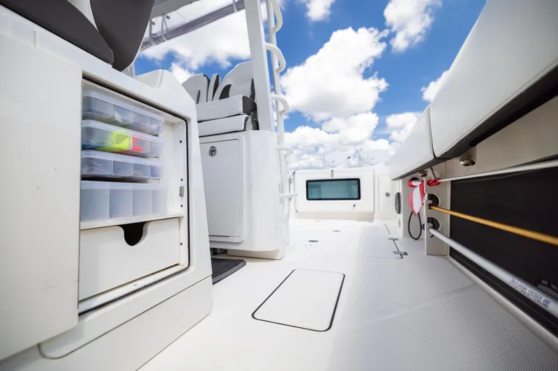 Slide: The Image of 2022 World Cat 400 CC-X boat interior with storage compartments and seating under a blue sky. - 78