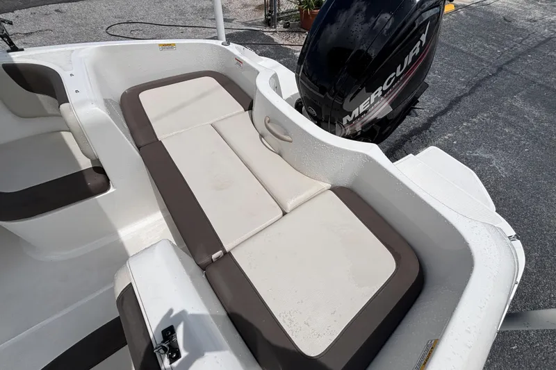 Slide: The Image of 2018 Bayliner Element E16 boat interior with cushioned seating and Mercury outboard motor. - 11