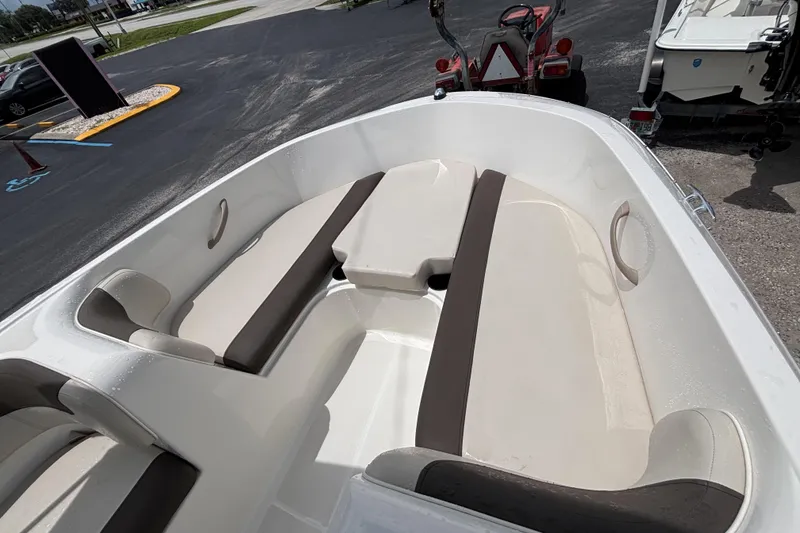 Slide: The Image of 2018 Bayliner Element E16 boat interior with beige and brown seating, parked outdoors. - 34