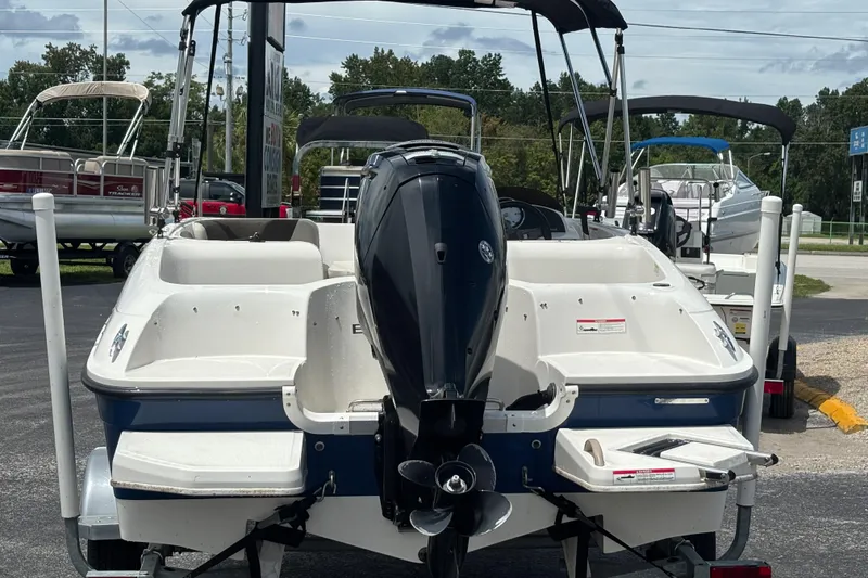 Slide: The Image of 2018 Bayliner Element E16 boat with outboard motor, parked on a trailer in a marina. - 4