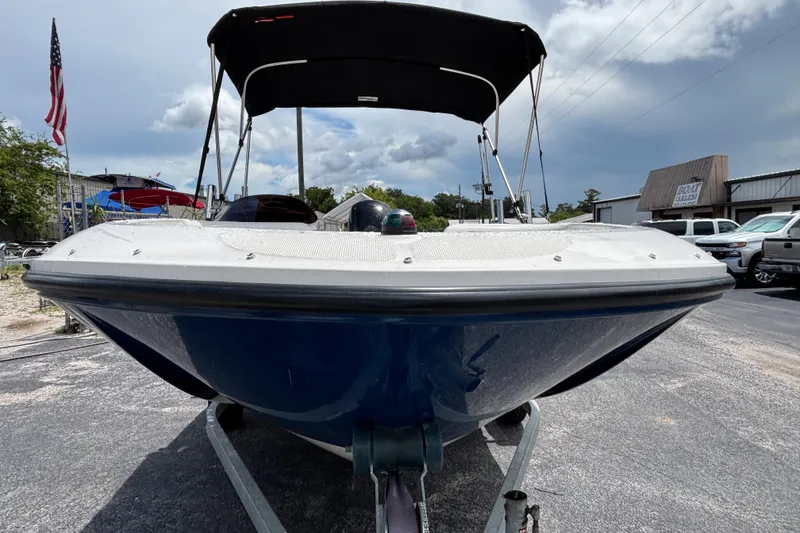 Slide: The Image of 2018 Bayliner Element E16 boat on trailer, parked outdoors under cloudy sky. - 7