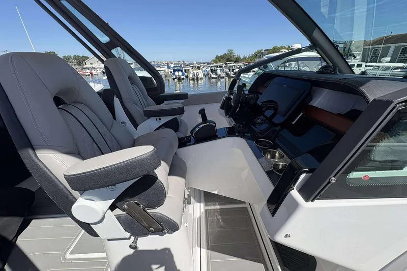 Slide: The Image of 2026 Monterey 27 Elite boat interior with modern helm and comfortable seating at marina. - 11