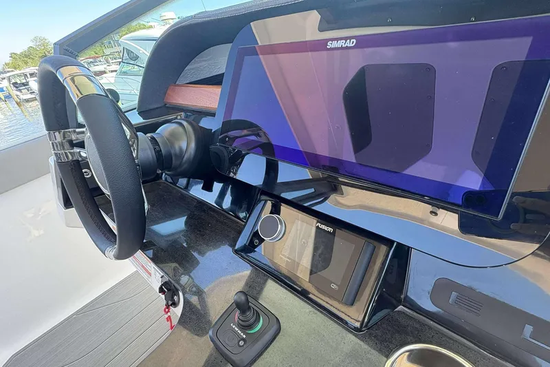 Slide: The Image of 2026 Monterey 27 Elite boat dashboard with steering wheel and Simrad display. - 13
