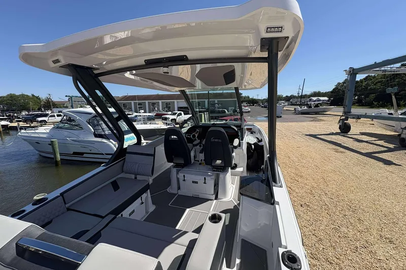 Slide: The Image of 2026 Monterey 27 Elite boat interior with seating and helm, docked at marina. - 4