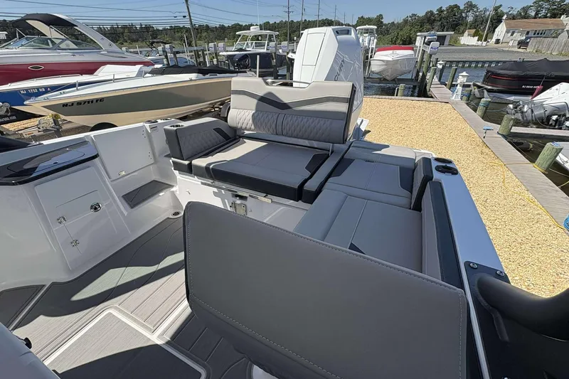 Slide: The Image of 2026 Monterey 27 Elite boat interior with sleek seating and modern design at a marina. - 5