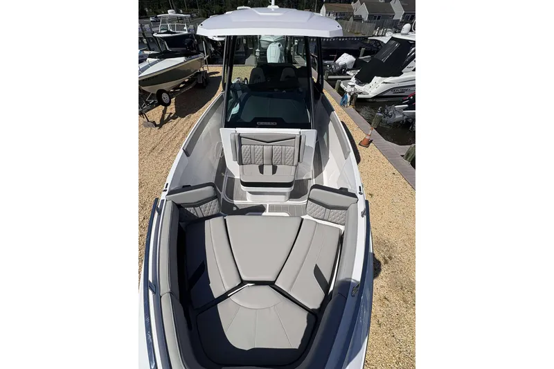 Slide: The Image of 2026 Monterey 27 Elite boat with sleek seating, docked at a marina. - 6