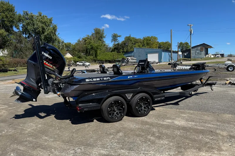 Slide: The Image of 2021 Skeeter FXR21 Apex boat with Yamaha engine on trailer, parked outdoors. - 1