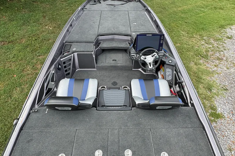 Slide: The Image of 2021 Skeeter FXR21 Apex boat on trailer, parked on grass with trees in background. - 10