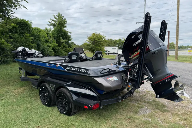 Slide: The Image of 2021 Skeeter FXR21 Apex boat on trailer under blue sky with clouds. - 3