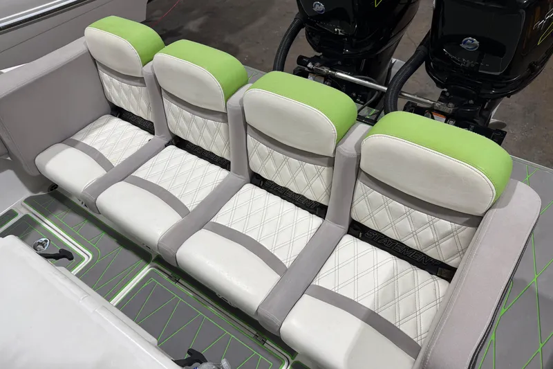 Slide: The Image of Four cushioned seats on a 2017 Statement 350 Open boat, featuring green and white upholstery. - 7
