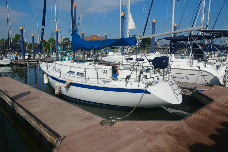 The Image of 1984 Ericson 38 sailboat docked at marina under clear blue sky. - 0