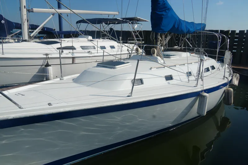 Slide: The Image of 1984 Ericson 38 sailboat docked, featuring sleek white hull and blue accents. - 1