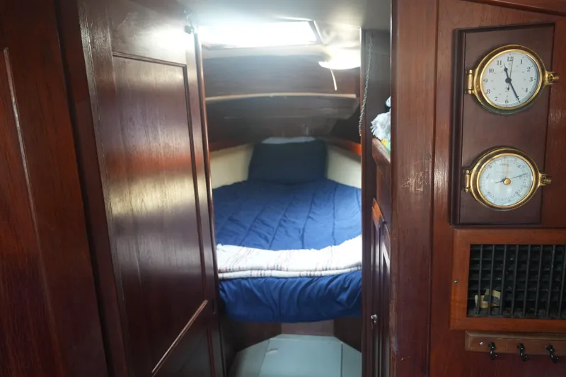 Slide: The Image of Cozy cabin interior of 1984 Ericson 38 sailboat with wood paneling and nautical instruments. - 12