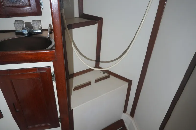 Slide: The Image of Interior of 1984 Ericson 38 sailboat featuring wooden cabinetry and compact sink area. - 15