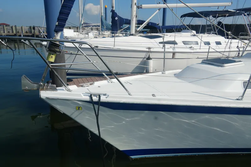 Slide: The Image of 1984 Ericson 38 sailboat docked in marina, featuring sleek white hull and blue accents. - 2