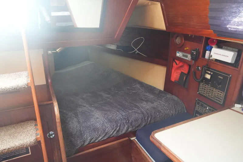 Slide: The Image of Interior of 1984 Ericson 38 sailboat with cozy sleeping area and navigation equipment. - 21
