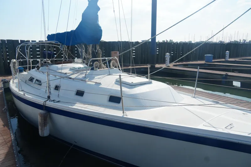 Slide: The Image of 1984 Ericson 38 sailboat docked at marina, featuring white hull and blue accents. - 4