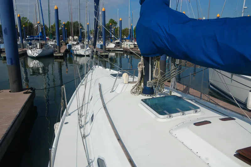 Slide: The Image of 1984 Ericson 38 sailboat docked in marina, featuring blue sail cover and clean deck. - 7
