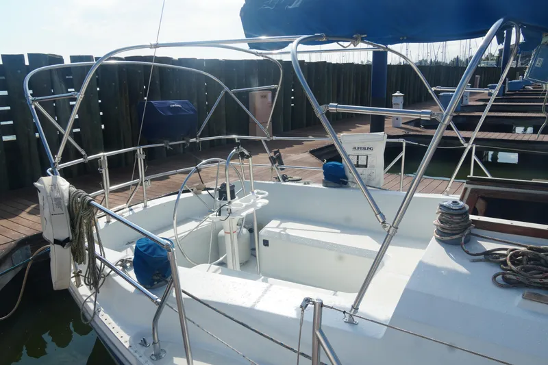Slide: The Image of 1984 Ericson 38 sailboat cockpit with steering wheel, docked at marina. - 8