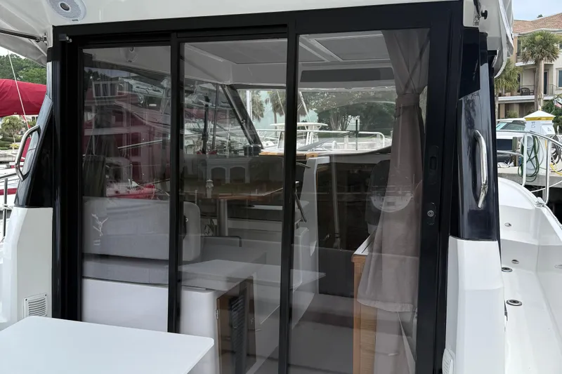 Slide: The Image of 2020 Jeanneau NC 895 boat interior with sliding glass doors and seating area. - 10