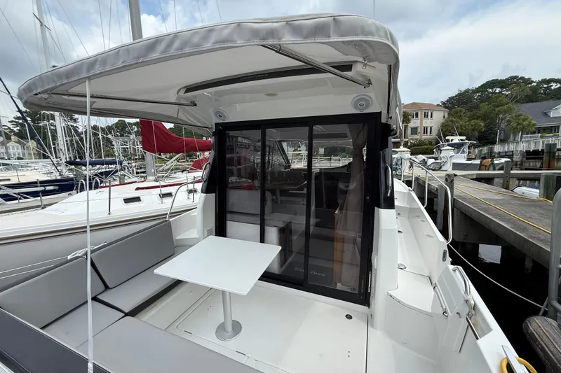 Slide: The Image of 2020 Jeanneau NC 895 boat with outdoor seating and table at a marina. - 12