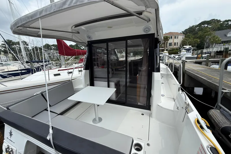 Slide: The Image of 2020 Jeanneau NC 895 boat with outdoor seating and table at a marina. - 13