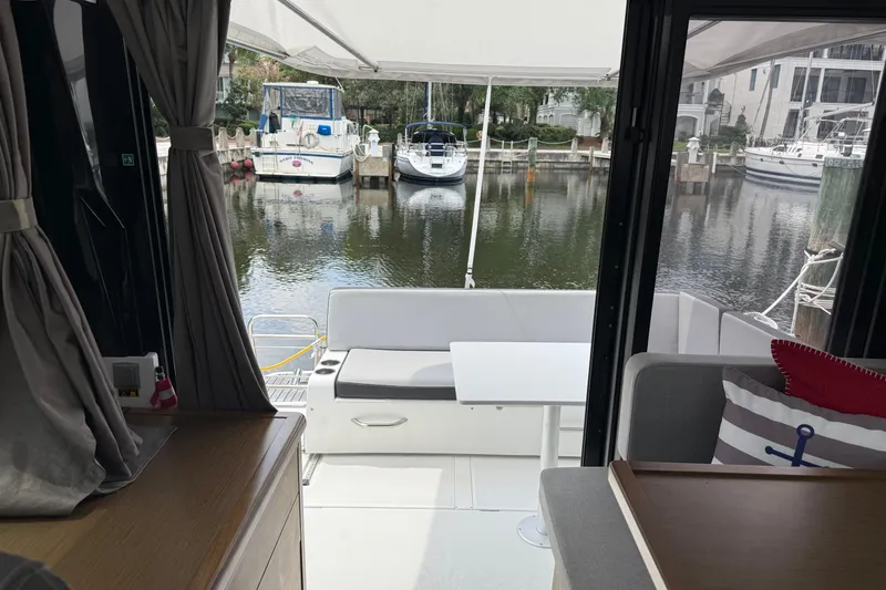 Slide: The Image of Interior view of 2020 Jeanneau NC 895 yacht with marina backdrop. - 25