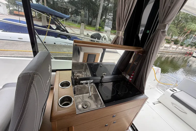 Slide: The Image of Interior view of a 2020 Jeanneau NC 895 boat with kitchenette and seating area. - 27