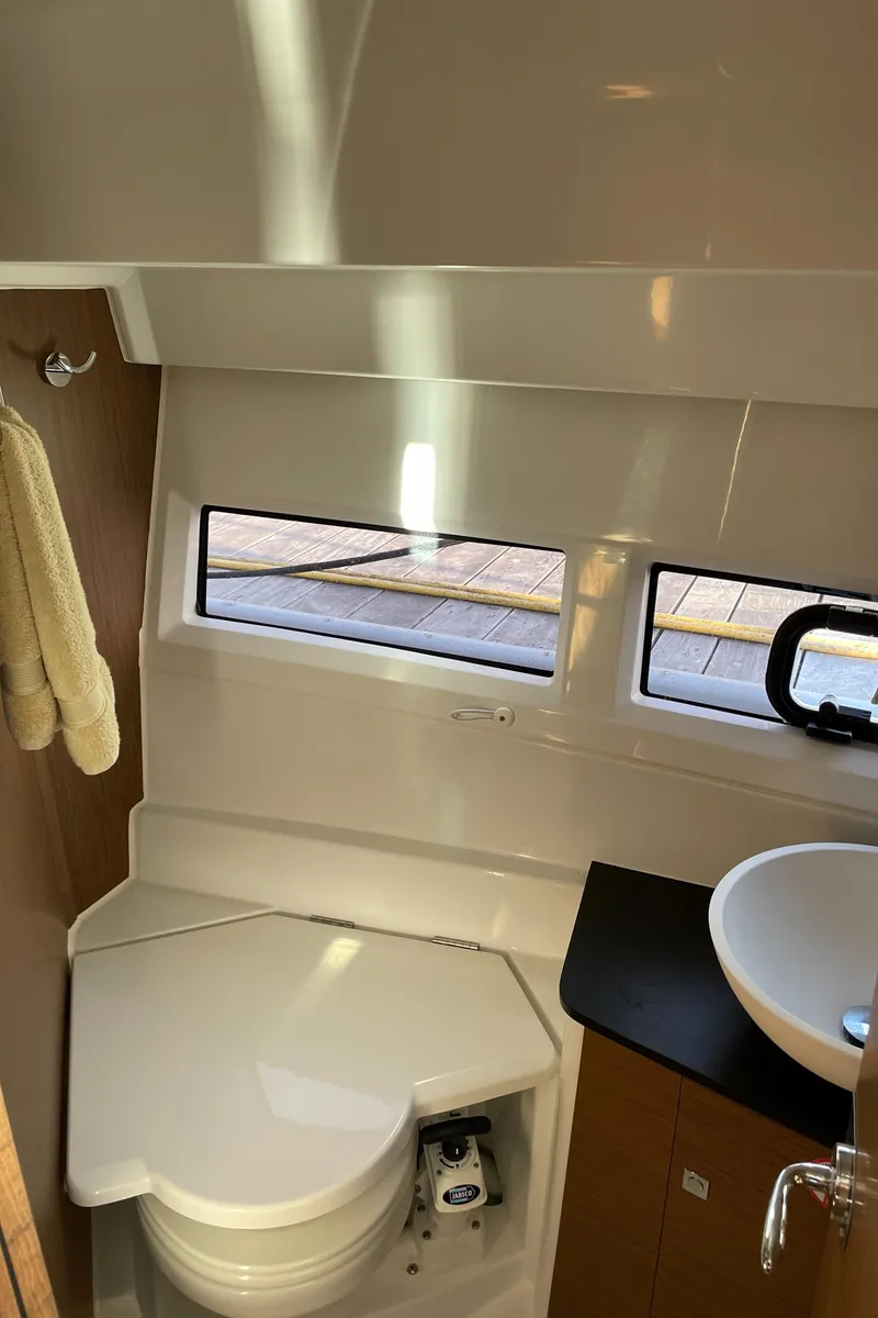 Slide: The Image of 2020 Jeanneau NC 895 boat bathroom with toilet, sink, and windows. - 37