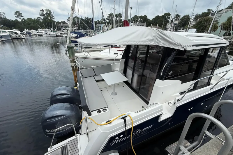 Slide: The Image of 2020 Jeanneau NC 895 boat docked with twin Yamaha engines, marina background. - 7