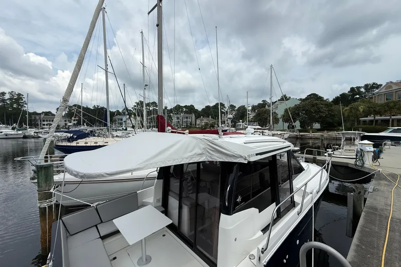 Slide: The Image of 2020 Jeanneau NC 895 docked at a marina under cloudy skies. - 9
