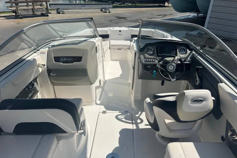 Slide: The Image of 2016 Chaparral 230 Suncoast boat interior with white seating and wood-style flooring. - 9