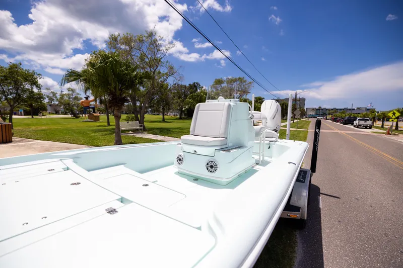 Slide: The Image of 2024 Yellowfin 24 CE boat on trailer, parked near a grassy area under a clear sky. - 10