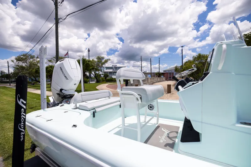 Slide: The Image of 2024 Yellowfin 24 CE boat with Mercury engine, docked under a cloudy sky. - 12