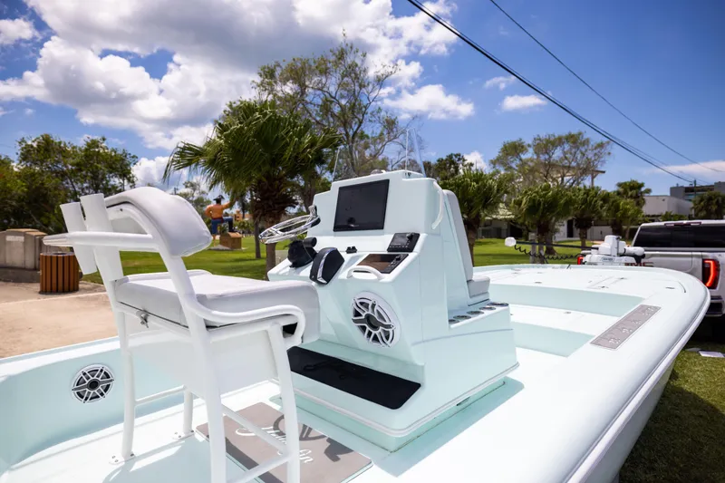 Slide: The Image of 2024 Yellowfin 24 CE boat with modern console and seating, parked outdoors under a blue sky. - 13