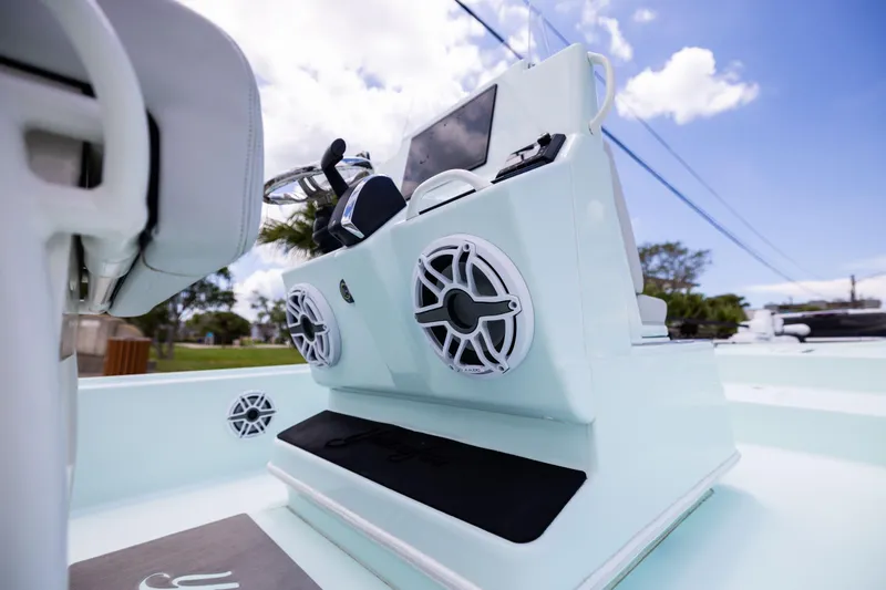 Slide: The Image of 2024 Yellowfin 24 CE boat interior with speakers and steering wheel, under a clear blue sky. - 16