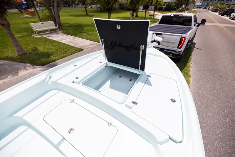 Slide: The Image of 2024 Yellowfin 24 CE boat on trailer, open storage compartment, parked near a road. - 20