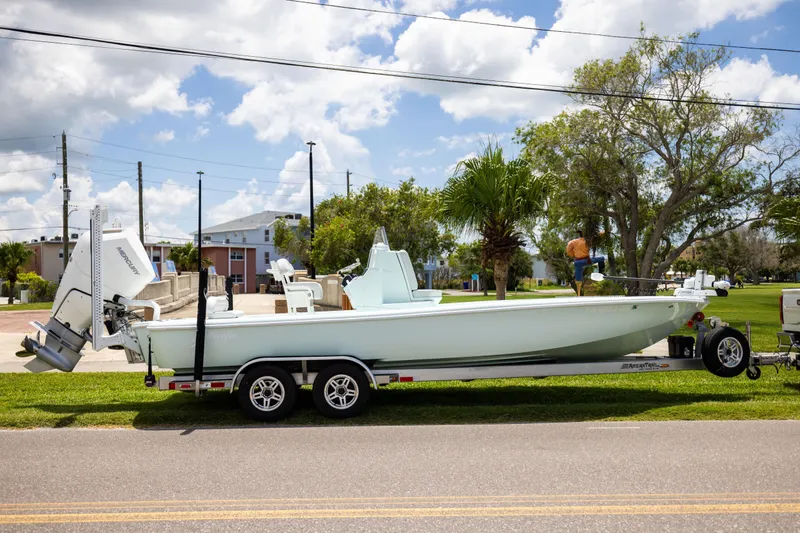 Slide: The Image of 2024 Yellowfin 24 CE boat on trailer, parked outdoors under a blue sky. - 3