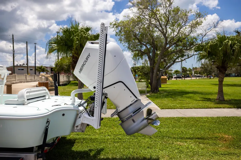 Slide: The Image of 2024 Yellowfin 24 CE boat with Mercury outboard motor, parked on grass under a cloudy sky. - 7