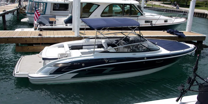 Slide: The Image of 2024 Formula 270 Bowrider boat docked at marina with canopy and sleek design. - 5