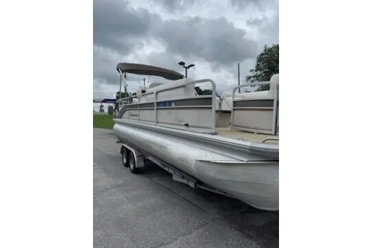 Slide: The Image of 2006 Premier 225 Legend pontoon boat on trailer under cloudy sky. - 3