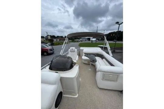 Slide: The Image of 2006 Premier 225 Legend pontoon boat with spacious seating and canopy under cloudy skies. - 6