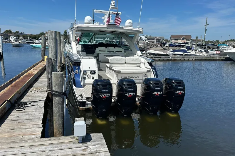 Slide: The Image of 2017 Formula 430 Super Sport Crossover boat on calm water, blue and white design. - 1