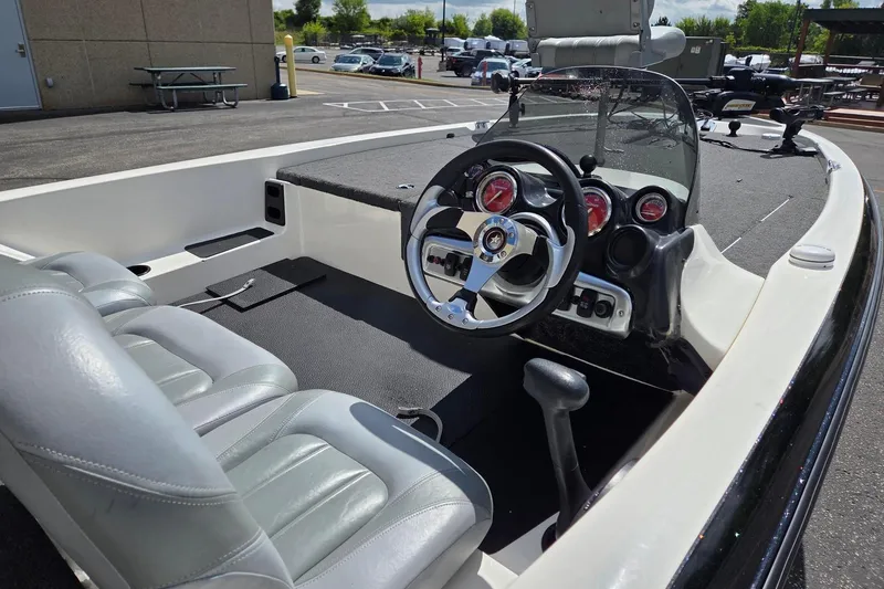Slide: The Image of 2011 Stratos 186XT boat interior with steering wheel and seating in a parking lot. - 6