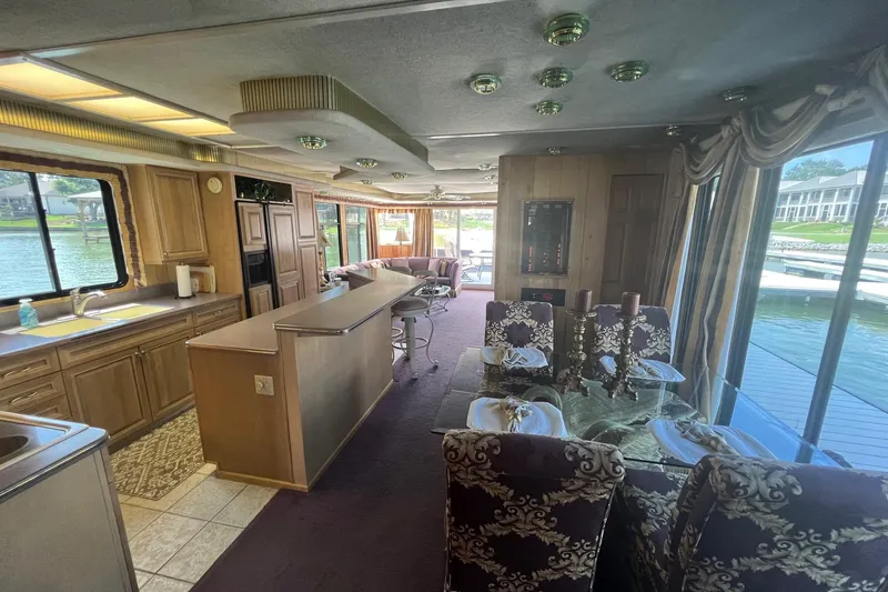 Slide: The Image of Luxurious 1998 Sumerset 16x80 houseboat interior with elegant dining area and kitchen, overlooking water. - 3